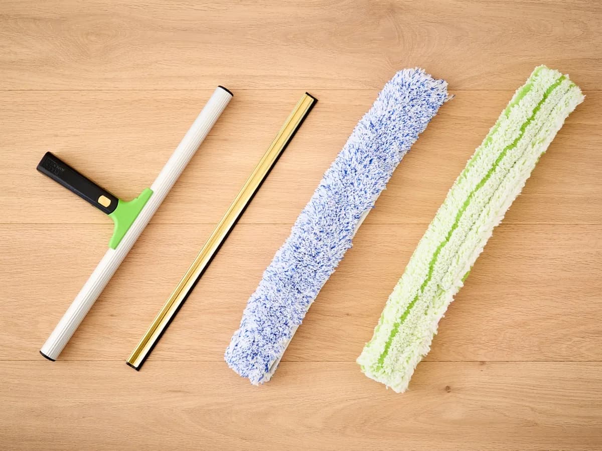 Window cleaning tools laid out ready: squeegee, brass channel and washer sleeves