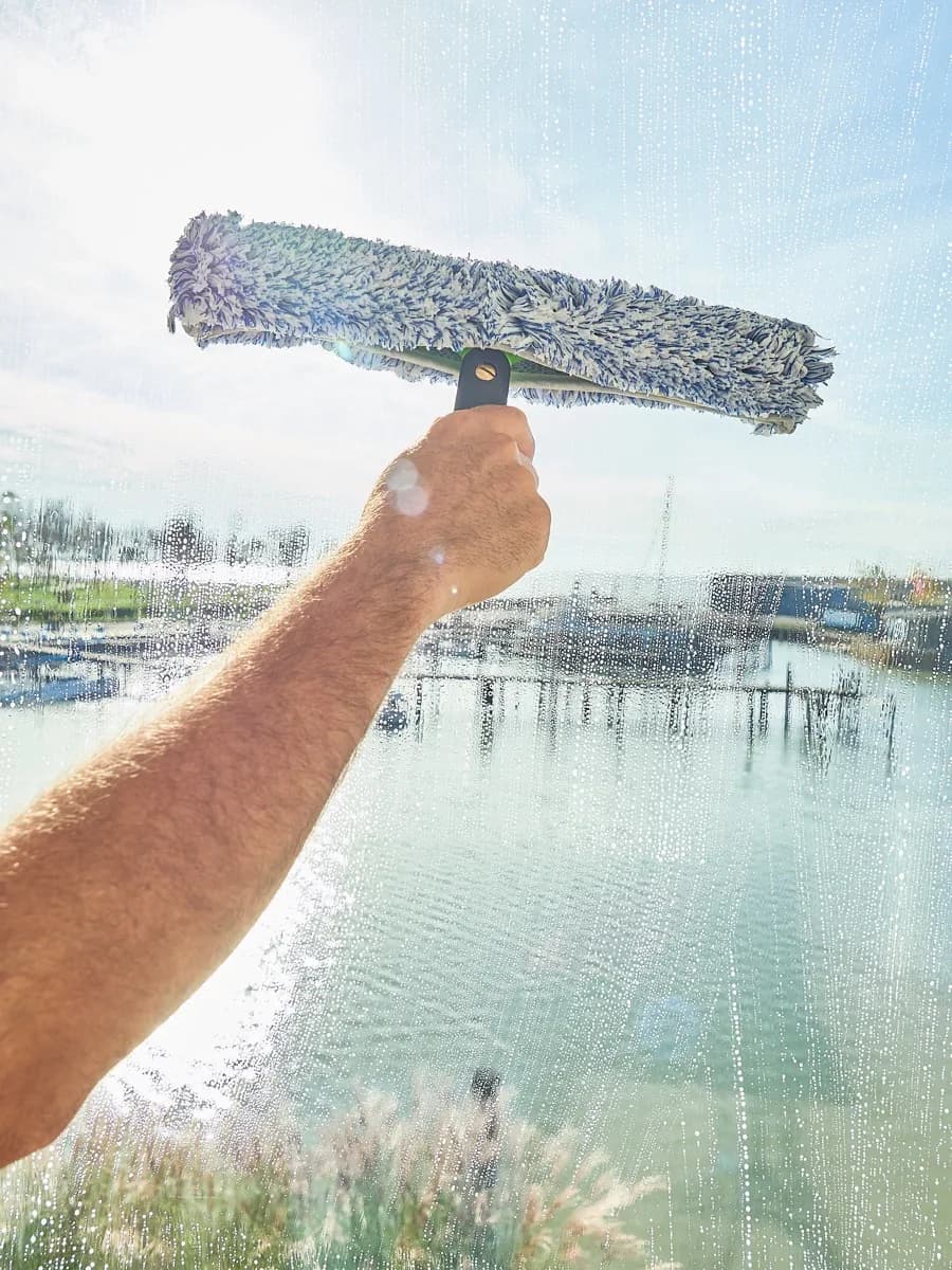 Washing the glass with a soaked sleeve to lift and release the dirt