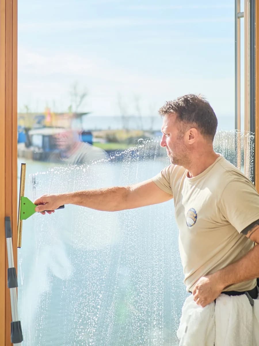 Pulling the squeegee across the wet glass in one clean stroke