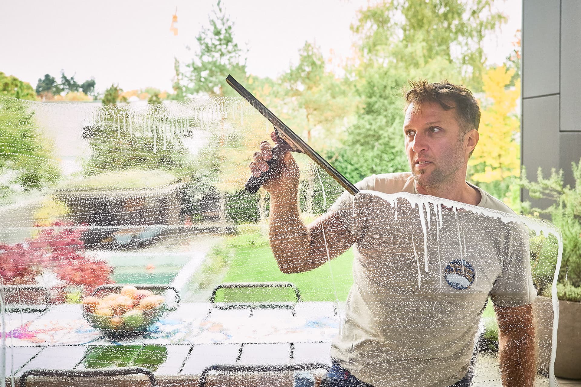 Justin Orloff drawing a squeegee down a window on location