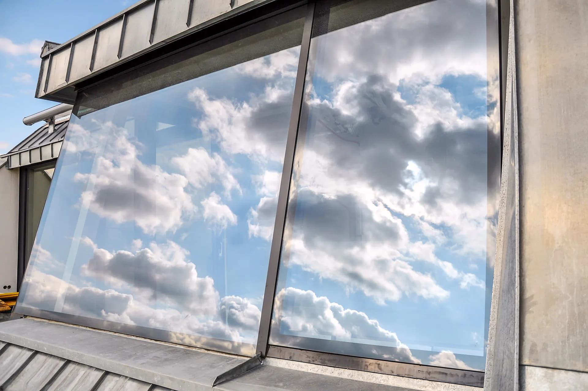 Spotless window glass reflecting a blue sky and white clouds