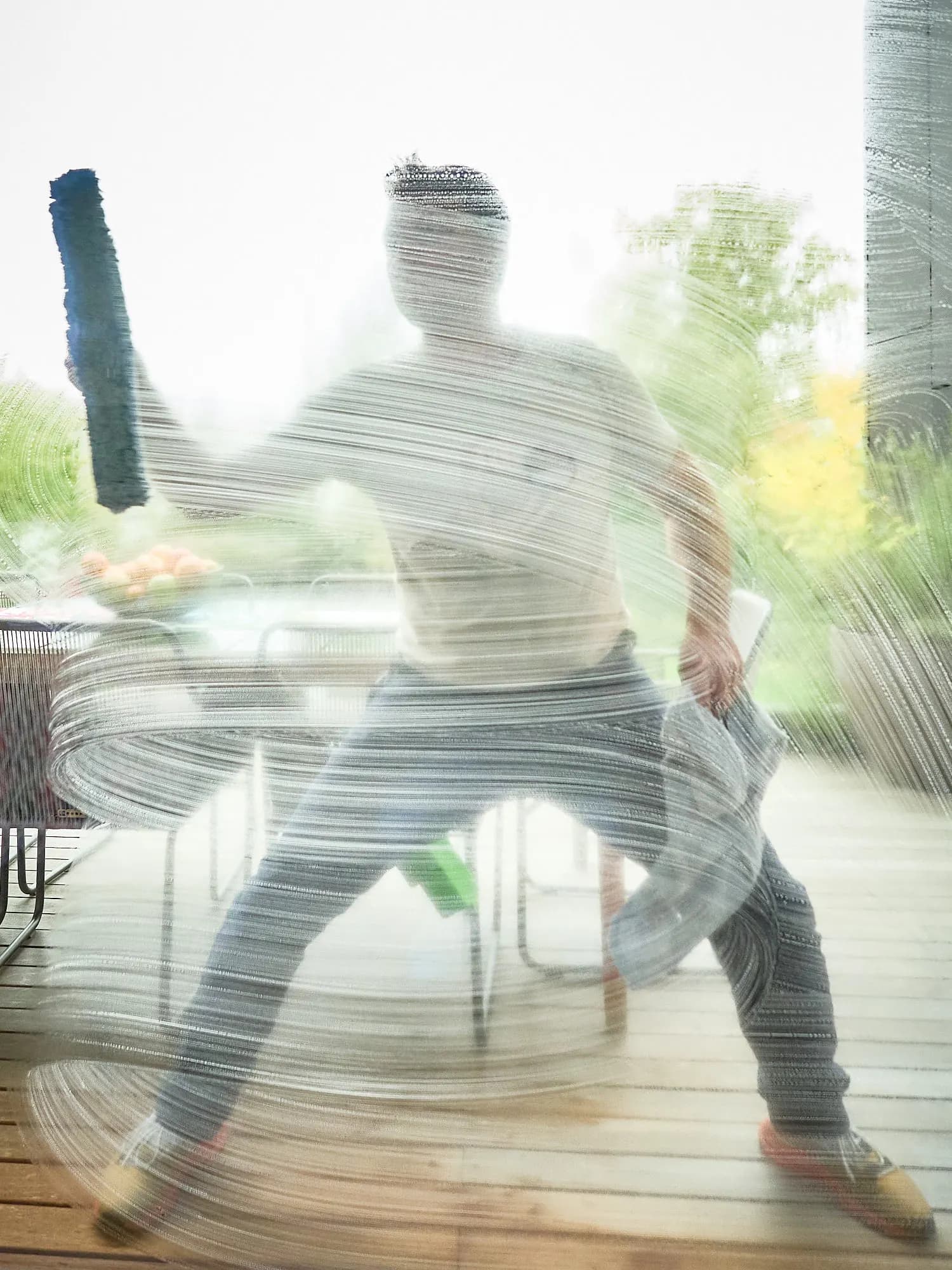 Justin Orloff seen through a soapy window, swinging the applicator through big soap spirals